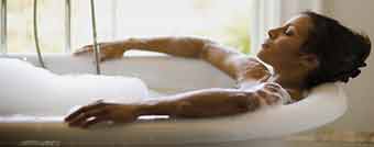 Woman relaxing in tub in her remodeled bathroom